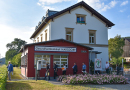 : Ein historisches Bahnhofsgebäude neben einem Bahnhaltepunkt wurde zum  Gesundheitszentrum umgebaut und Gesundheitsbahnhof genannt.